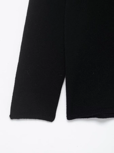 Close-up of the black knit sweater texture and seamless hem craftsmanship detail