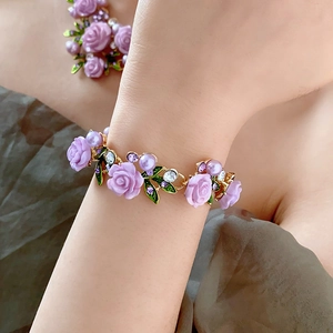 Vue détaillée d'un bracelet de perles à fleurs avec roses violettes et cristaux sur poignet