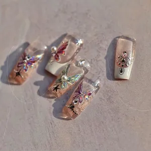 Detailed macro of long trapezoidal jelly nails with 3D butterflies, pearls and rhinestones