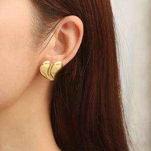 Fashionable two-tone 18K gold-plated stainless steel heart earring on female model
