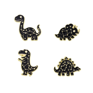Lot de quatre pin's dinosaures noirs avec motifs célestes dorés et yeux en cristal