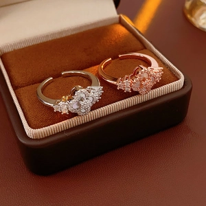 Detail showing rhodium and rose gold clover rings with shell inlay and zircon accents