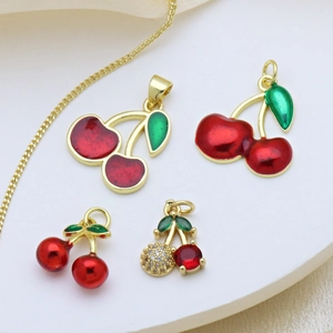 Fashionable golden cherry pendants with red enamel and rhinestones on a silk background