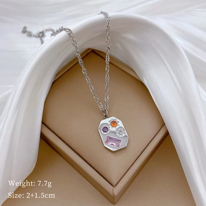 Macro detail of silver titanium necklace featuring colorful star and rectangle gems