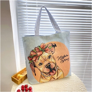Detail of blue-grey tote bag featuring a dog illustration and striped canvas straps