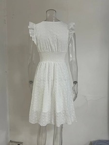 Détail de robe blanche en broderie anglaise avec col en V à volants et taille haute