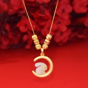 Détail du collier pendentif lune dorée et lapin en jade blanc sur fond floral rouge