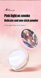Detail of loose powder showing fine pink texture and puff in elegant packaging