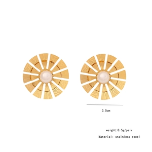 Detail view of gold stainless steel sunburst earrings with centered white faux pearls