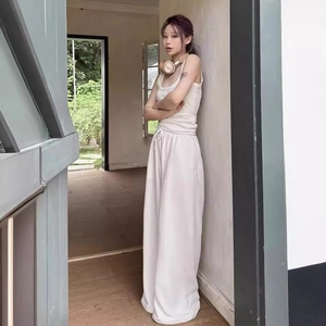 Detail view of a model wearing a chic off-white two-piece tank top and wide-leg trousers set