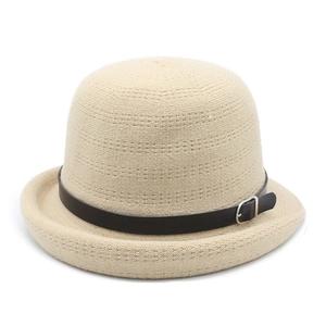 Detailed view of beige knitted cloche hat with black leather strap and metal buckle
