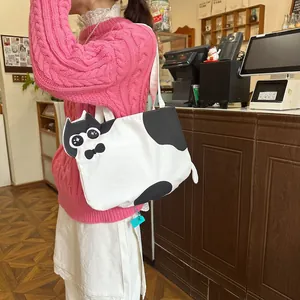 Detail of cute cat-shaped white canvas tote bag with 3D bowknot and embroidery on a model