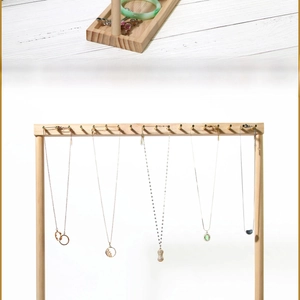 Detail of solid wood jewelry stand featuring metal hooks for necklace and bracelet storage