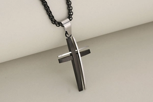 Detail shot of the dual-layer hollow cross pendant in matte black and silver finish