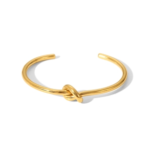 Nahaufnahme des goldenen Knotendesigns am polierten Edelstahl-Armreif mit Öffnung