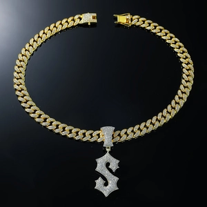 Hip hop style gold Cuban chain necklace featuring a sparkling iced-out letter S pendant