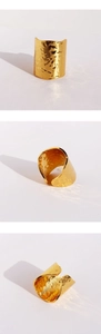 Three-way view of a wide gold ring with molten lava texture and hammered finish details