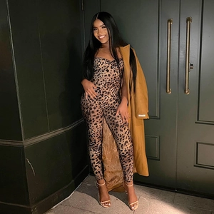 Detail of leopard print jumpsuit styled with a long camel wool coat and matching belt