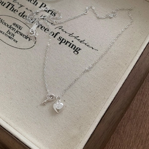 Minimalist 925 sterling silver heart lock and key pendant necklace on a jewelry box