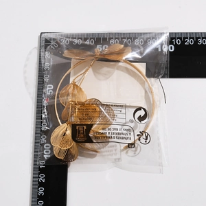 Detailed measurement of gold ginkgo leaf and butterfly choker necklace on scale