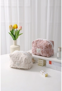 Close-up of floral lace embroidery on cream and rose corduroy makeup bags
