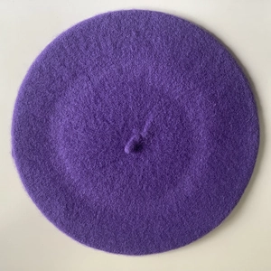 Top down close-up view of dark purple wool blend beret with soft fleece texture