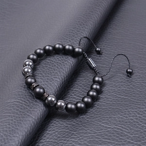 Detailed close-up of volcanic stone and tiger eye beads on an adjustable woven bracelet