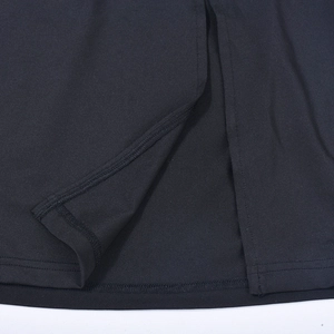 Detailed close-up of the side slit and double-stitched hem on a black woven mini skirt