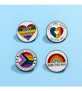 Set of four colorful rainbow enamel pins with inclusive love quotes on blue background