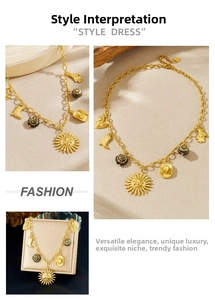 Detail of vintage gold-plated necklace featuring sun, cowboy hat, and heart charms