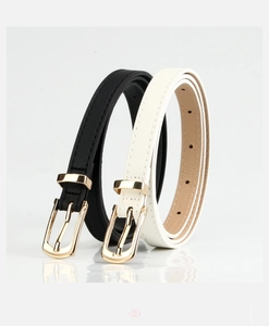 Detail view of black and white slim PU leather belts with golden pin buckles on white surface