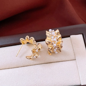 Detailed view of 14k gold-plated C-shaped earrings with pearls and small zircons