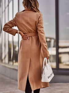 Detail view of the back slit and tailored cut of this camel wool blend long coat for women