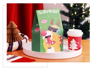 Close-up of Christmas gift bag and paper cup set with festive green and red design