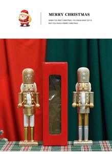 Close-up of glittery white nutcrackers with gold and silver accents in a red gift box