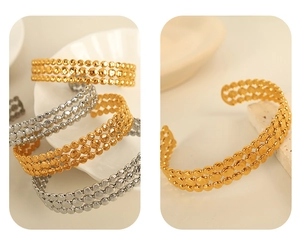 Detail view of gold and silver open bracelets with multi-row beaded texture
