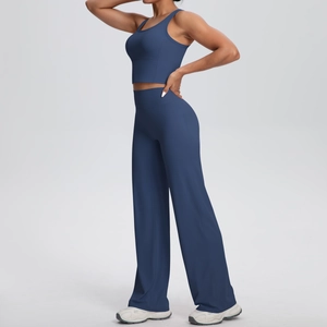 Dettaglio completo fitness blu scuro con crop top a vogatore e pantaloni yoga larghi