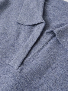 Macro detail of high-quality navy blue cashmere blend knit polo shirt stitching texture
