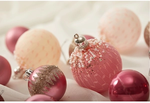 Detailansicht der rosa und beige Weihnachtskugeln mit feiner Spitze und Perlen