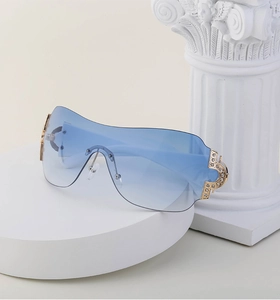 Detailed macro view of blue gradient rimless sunglasses with gold rhinestone temple accents