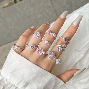Close-up of S925 silver rings with pink heart and butterfly zircon stones on fingers