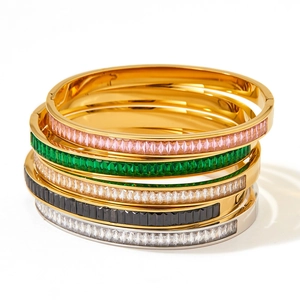 Détail de cinq bracelets empilables en acier inoxydable sertis de zircons colorés