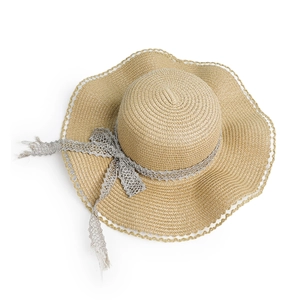 Detailed close-up of woven straw hat with wavy brim and translucent silver lace trim