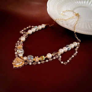 Detail of vintage pearl necklace with crystal beads and a gold heart pendant charm