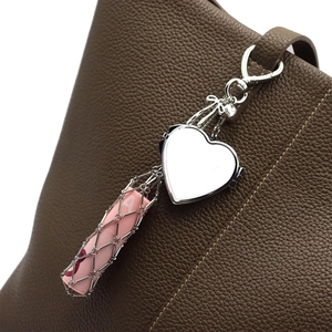 Silver stainless steel mesh lipstick holder with heart mirror charm on leather bag