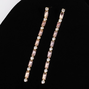 Detail of elegant 18K gold plated tassel earrings with pink and white zirconia stones