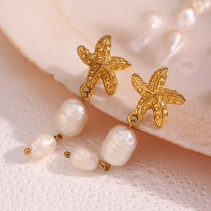 Macro shot of 18K gold plated starfish earrings with baroque pearls and water droplets