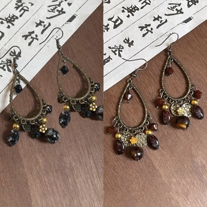 Detailed view of vintage water-drop earrings with ethnic beads on a rustic wooden background