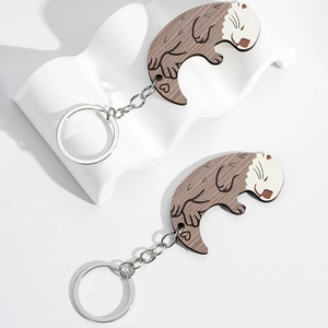 Pair of wooden sea otter keychains with realistic grain texture and metal rings