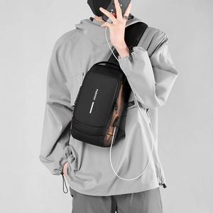 Close-up of black crossbody bag with USB charging port and vertical fashion text print